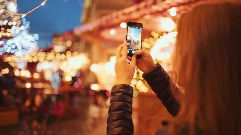 woman taking pictures of christmas lights